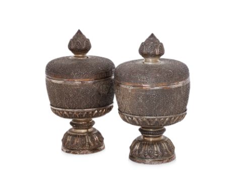 A PAIR OF THAI SILVER PLATED BOWLS, COVERS AND STANDS Repoussé and chased with dense foliate scrollwork, each raised on a lot