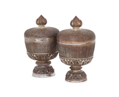 A PAIR OF THAI SILVER PLATED BOWLS, COVERS AND STANDS
Repoussé and chased with dense foliate scrollwork, each raised on a lot
