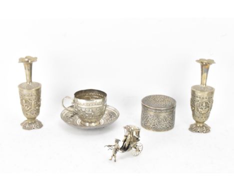 A small collection of Indian white metal implements including two vases with crimped tips and embossed with panels depicting 