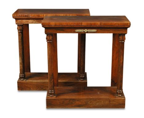 A pair of Regency rosewood console tables, in the French manner with gilt brass frieze mounts, lapit carved columns to a plin