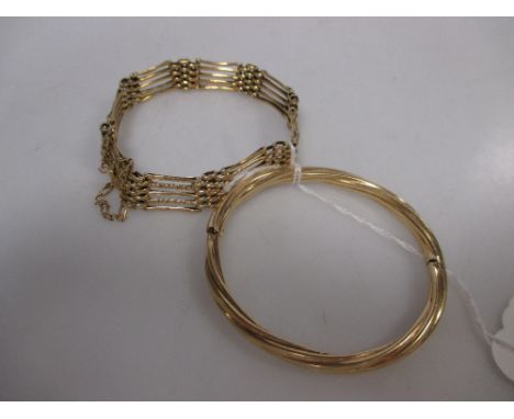 A five bar gate bracelet stamped 18k (13.7g) together with gold hinged bangle stamped 585 (12.5g) (2)  
