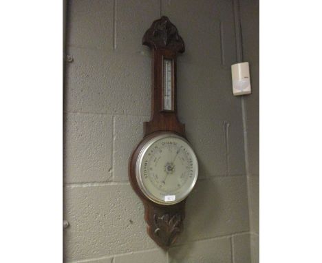 An oak banjo barometer with a clock.  