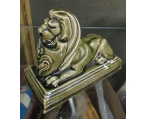 A Poole (Carter's Tiles) retailer's gift figure of a reclining lion  