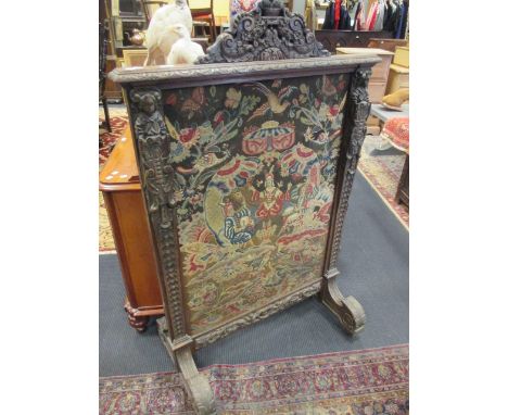 A carved oak screen with needlework panel, 142cm in height.  