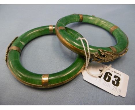 A pair of Chinese Jade bangles (damaged) with gilt white metal dragon mounts