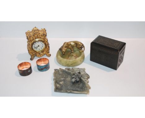 A tray lot including an onyx ashtray decorated with a figure of a tiger, gilt-metal clock, cloisonné napkin rings etc&nbsp; C