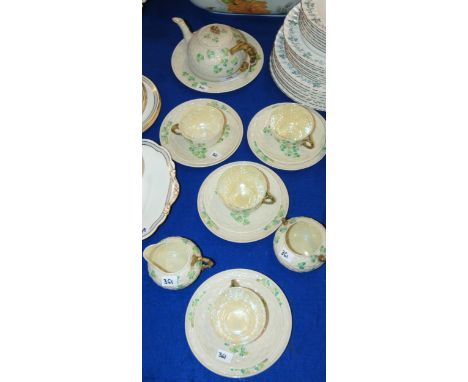 A Belleek shamrock decorated teaset comprising teapot, cake plate, sugar bowl, milk jug and four trio's Condition Report:Avai