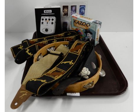 A Behringer BD121 bass effect pedal together with three fender guitar straps, a tambourine, assorted Jimmi Hendix cigarette c