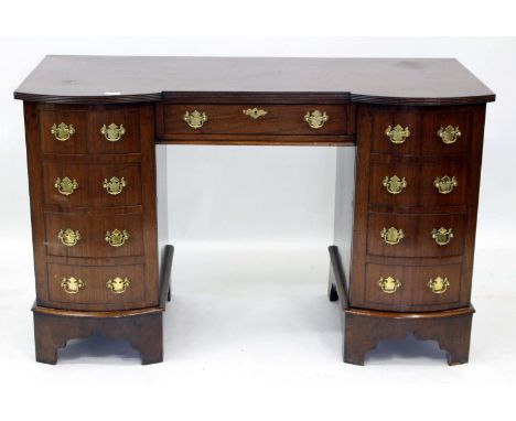 A MAHOGANY PEDESTAL DESK each bow fronted pedestal with a cupboard door with faux drawer fronts and fitted within either side