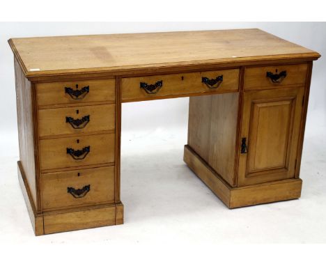 AN EARLY 20TH CENTURY OAK PEDESTAL DESK with drawers to the frieze and down one side and with a panel cupboard door to the ot