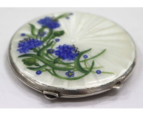 A MID 20TH CENTURY CIRCULAR SILVER ENAMEL DECORATED COMPACT painted with flowers to the front 6.7cm diameter
