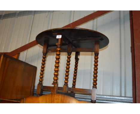 An oak occasional table raised on bobbin turn supports