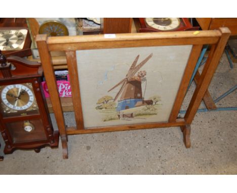 A mahogany framed and needlework firescreen depicting a windmill 