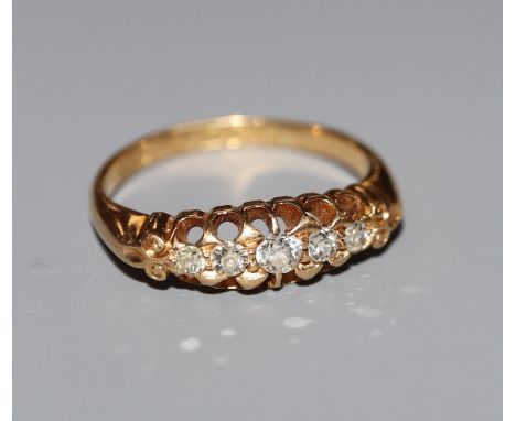An early 20th century 18ct gold and graduated five stone diamond half hoop ring, size M.