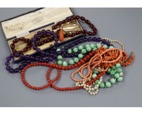 Assorted necklaces including coral and amethyst, a carved coral pendant and a pair of folding lorgnettes.