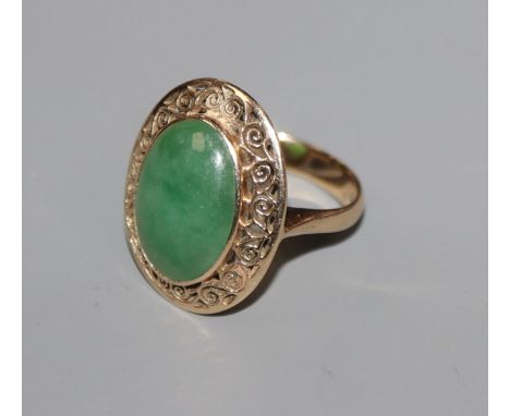 A yellow metal and oval cabochon jade dress ring, size I.