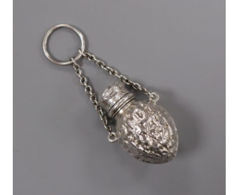 A late 19th/early 20th century novelty white metal scent flask, modelled as a walnut, unmarked, with suspension chain, 39mm.