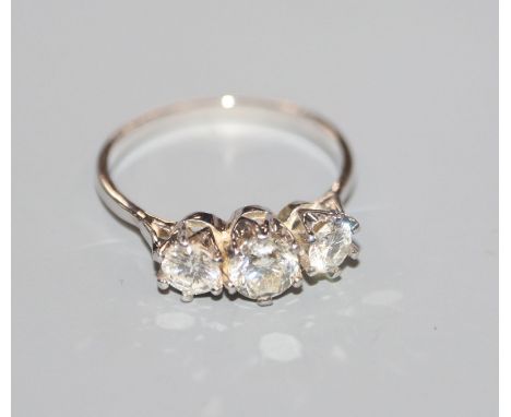 An 18kt white metal and three stone diamond ring, total diamond weight approximately 1.00ct, size O.