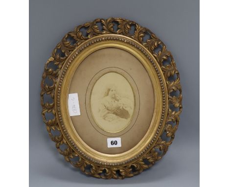 An oval pierced gilt frame with photographic portrait