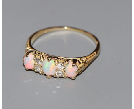 An 18ct, three stone white opal and four stone diamond half hoop ring, size P.