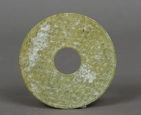 A Chinese carved jade roundel
With pierced centre and carved geometric decorations.  13 cm diameter.  CONDITION REPORTS: One 