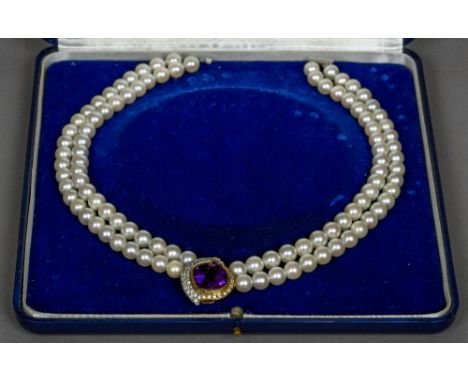 A two strand pearl necklace
Centred with a diamond and amethyst set 18 ct gold mount.  40 cm long.  CONDITION REPORTS: Genera