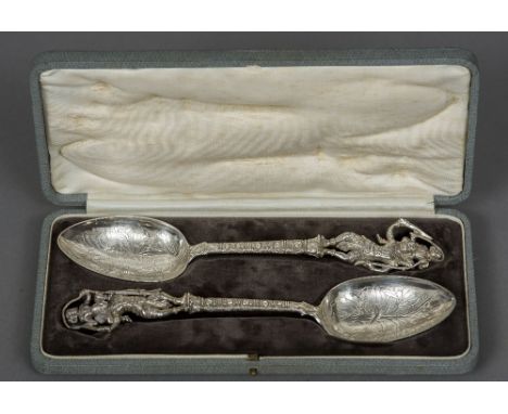 A pair of Eastern white metal figural tablespoons
Each with figural cast finial and stem, the bowls engraved, maker's mark of