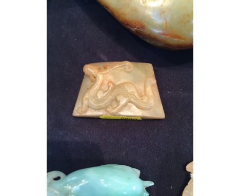 A Chinese carved jade pendant
One side decorated with a dragon; together with a jade model of an oxen; and a small jade model