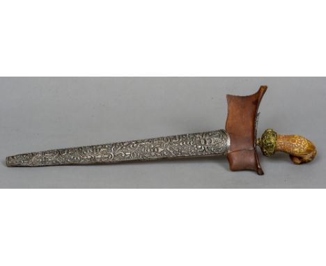 A 19th century ivory handled Kris
The florally carved handle with a cabochon stone inset mount, the scabbard with a wooden co