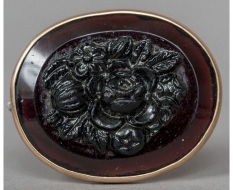 A yellow metal framed amethyst coloured brooch
Of oval form, worked with flowers.  4 cm wide.  CONDITION REPORTS: Generally i