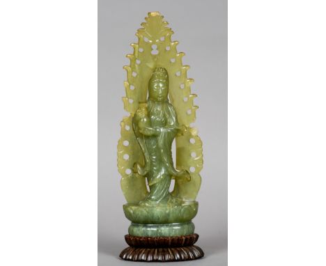 A Chinese carved jade model of Guanyin
Modelled holding a bottle vase, mounted on a carved hardwood stand.  31 cm high. CONDI