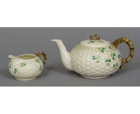A Belleek porcelain teapot and cream jug
With typical basket weave and shamrock decoration with Second Period black printed f