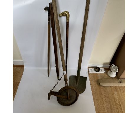 A collection of walking sticks and farming tools