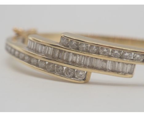 A 9ct Yellow Gold Diamond Bangle, Set with round brilliant cut diamonds + Baguette Cut Diamonds, approx 2.0cts total,11mm wid