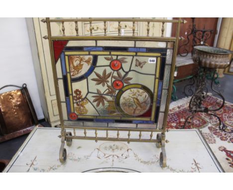 A Victorian aesthetic brass and stained glass fire screen. Inset panel of birds and insects.