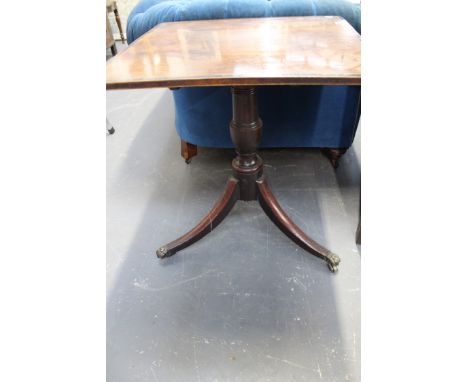 An inlaid Regency tilt top lamp table. Crossbanded top. Urn turned pedestal trifid sabre legs end in brass paw castors.