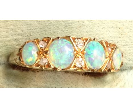 A gold four stone opal set ring with diamond points.