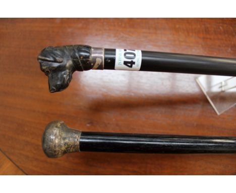 A late 19th Century ebony walking stick with carved hound dogs head finial and another ebony walking cane with silvered mount