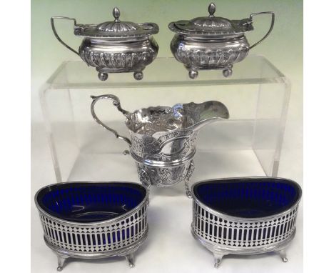 A pair of pierced oval silver table salts. London 1906, a pair of silver mustard pots. Birmingham 1904 together with a silver