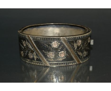 A Victorian silver Aesthetic movement hinge bangle, engraved and inlaid with a gold floral three section crest, H Bros, Birmi