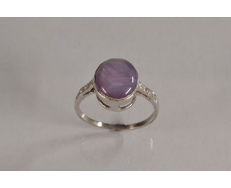 A star sapphire solitaire ring, pale creamy blue sapphire approx 7.30ct, set between diamond accented shoulders, estimated di