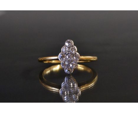 An Art Deco style marquis shaped diamond set dress ring, encrusted with nine round old cut diamonds, arranged in three rows o