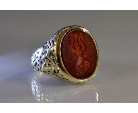 A gentleman's carnelian seal stamp signet ring, oval panel engraved  with a bear within off set shield, beneath plumed helm f