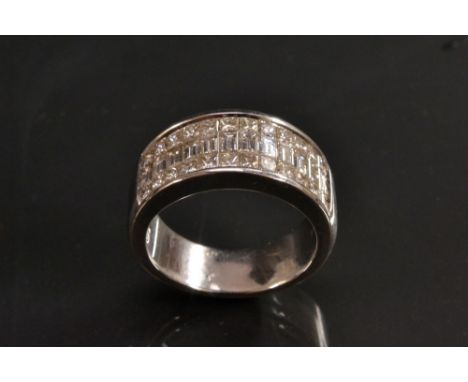 A diamond cluster ring, rectangular crest panel inset with twelve baguette cut and twenty four square princess cut diamonds, 