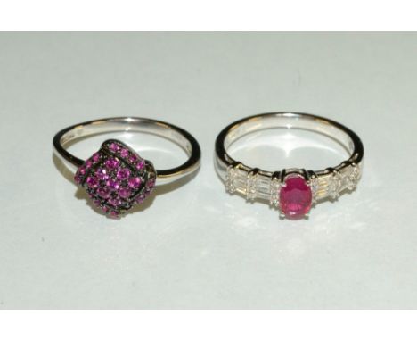 A ruby and diamond ring, central oval pinky red ruby, approx 0.60ct, quarter claw set above diamond shoulder inset with six b