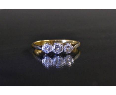 A diamond trilogy ring, central round brilliant cut diamond approx 0.22ct, flanked by conforming smaller stones, each approx 
