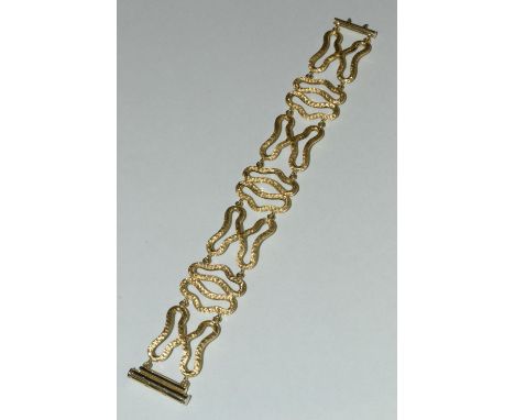 An Italian contemporary design articulated yellow metal free form panel bracelet, composed of seven textured panels, compress