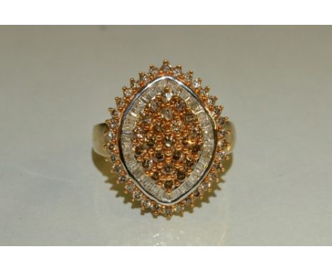 A cognac and white diamond cluster ring, central triple layer cluster of twenty three round cut cognac diamonds, surrounded b