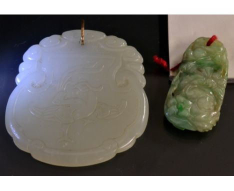 A Chinese carved pale green stone tablet pendant. possibly jade, decorated with a stylized bird beneath scrolling clouds, unm