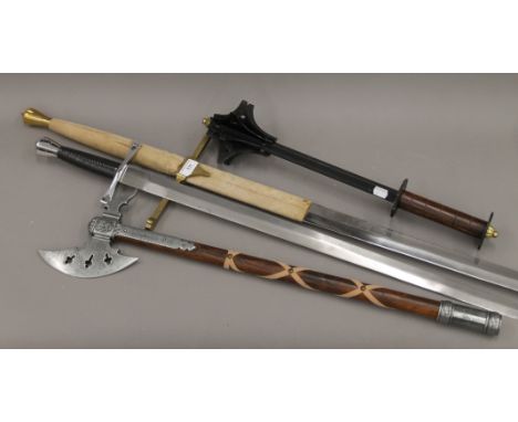 Four wall piece weapons including two swords, an axe and a mace. The largest 134 cm long.